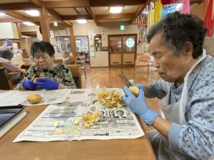 じゃがいもの皮をむく入居者の皆さん